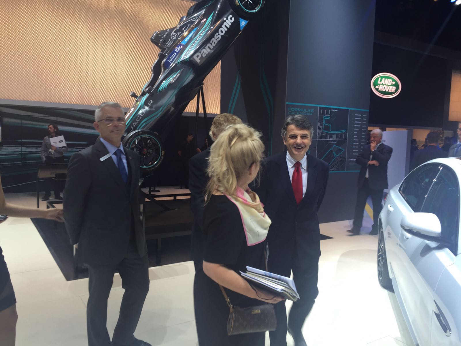 Jaguar Land Rover CEO Ralf Speth walks in front of Jaguar Racing’s formula-E vehicle with LIASE Group Non-Executive Board Member Vic H. Doolan (hidden). 